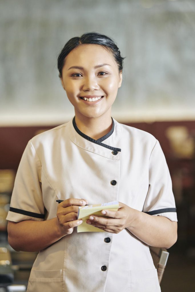 Asian waitress writing order