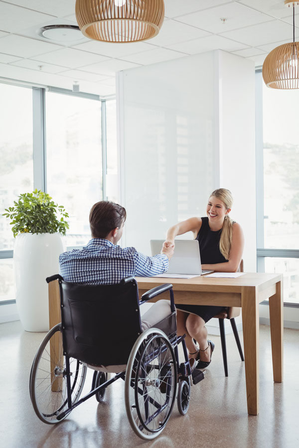 shaking hands with disability candidate in wheelchair