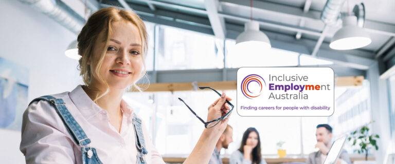 Young female at work looking at camera with inclusive Employment Australia logo